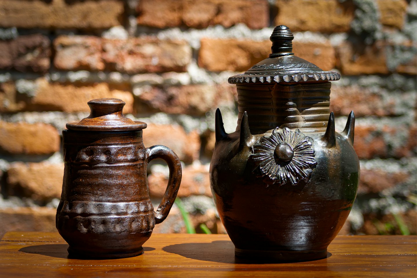 Dos macetas decorativas de cerámica sobre una mesa de madera.